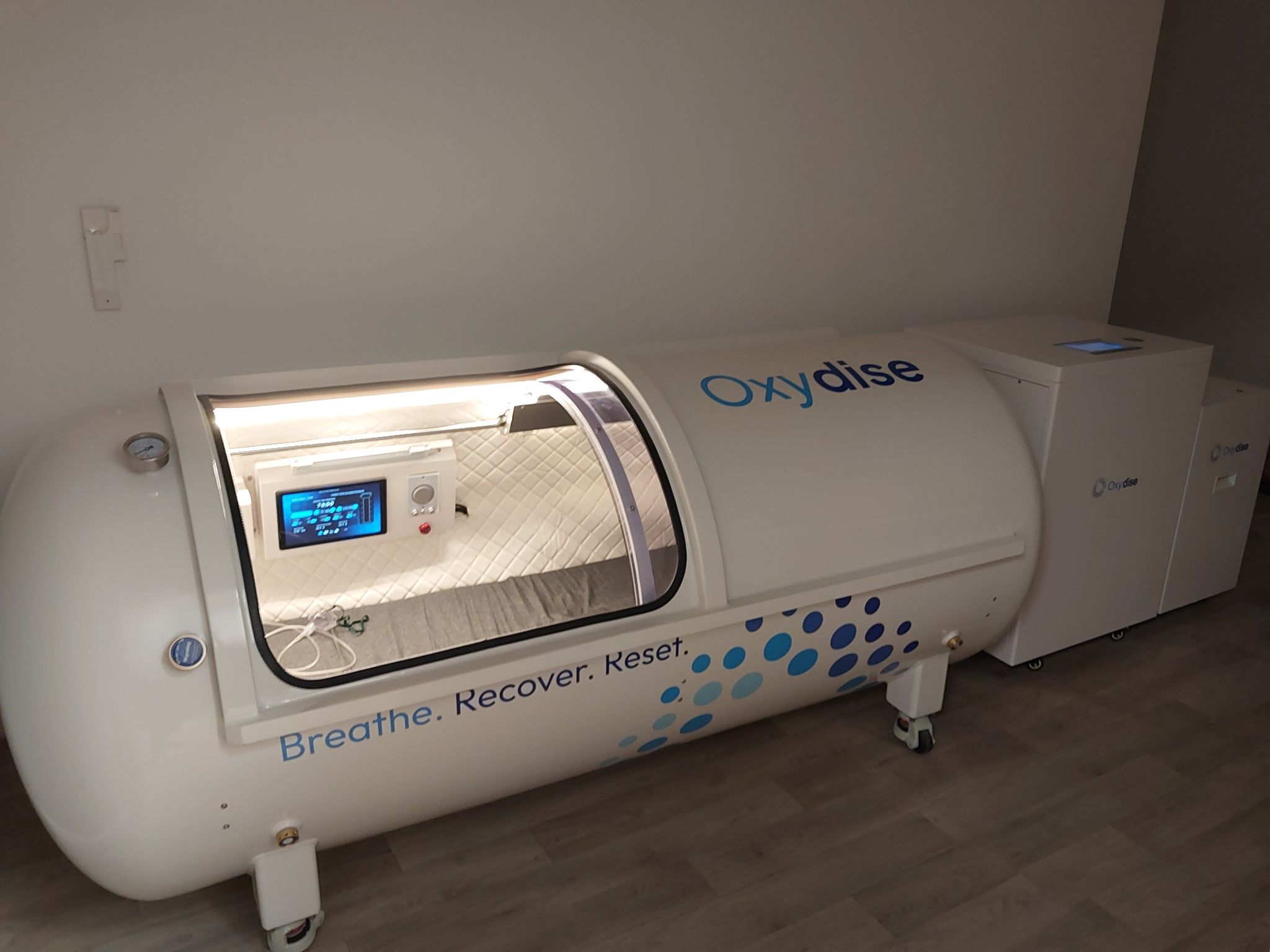 The real Oxydise hyperbaric oxygen chamber with its lit interior at our Derby clinic